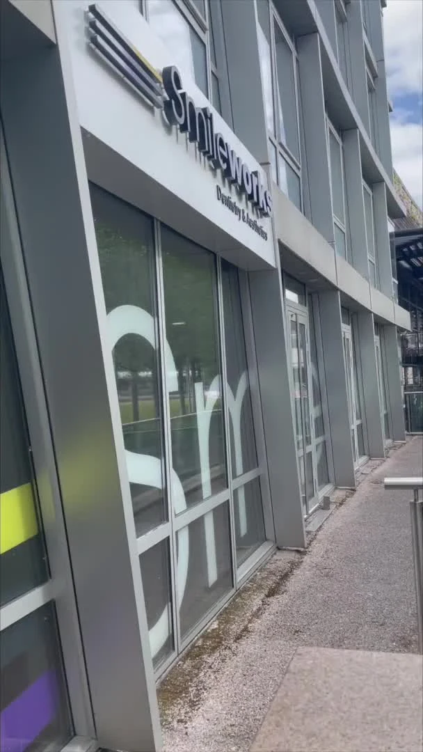 Smileworks sign and glass entrance doors beside the decking at One Park West.